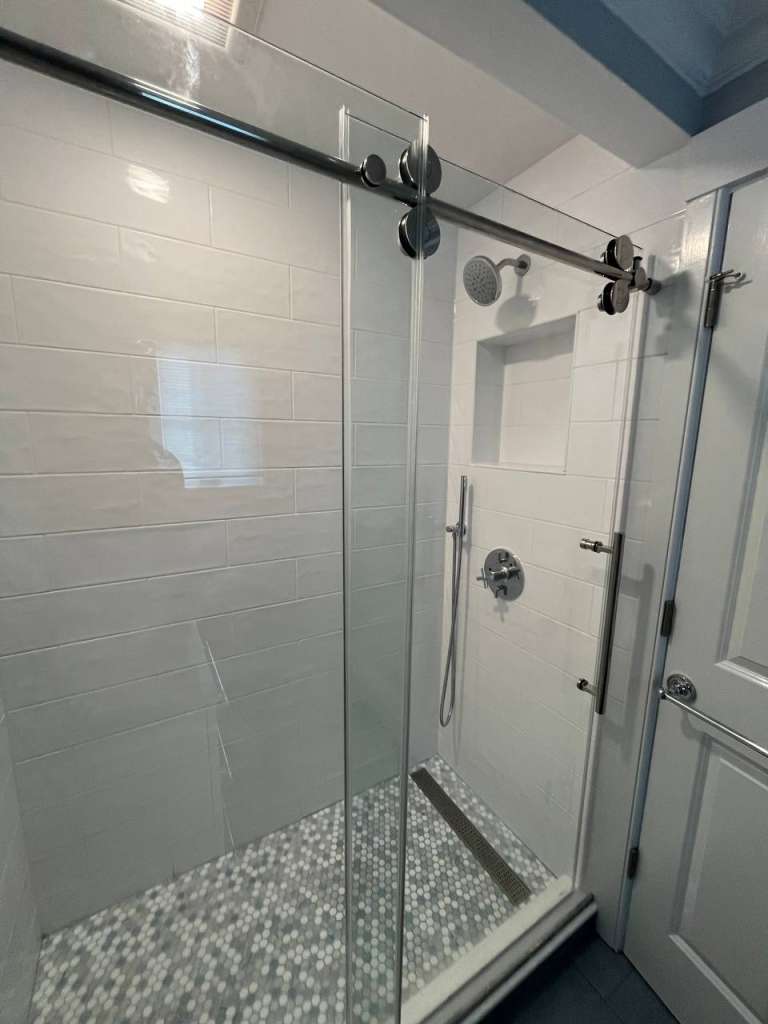 Subway tiles installed inside a walk-in shower during a bathroom remodel.