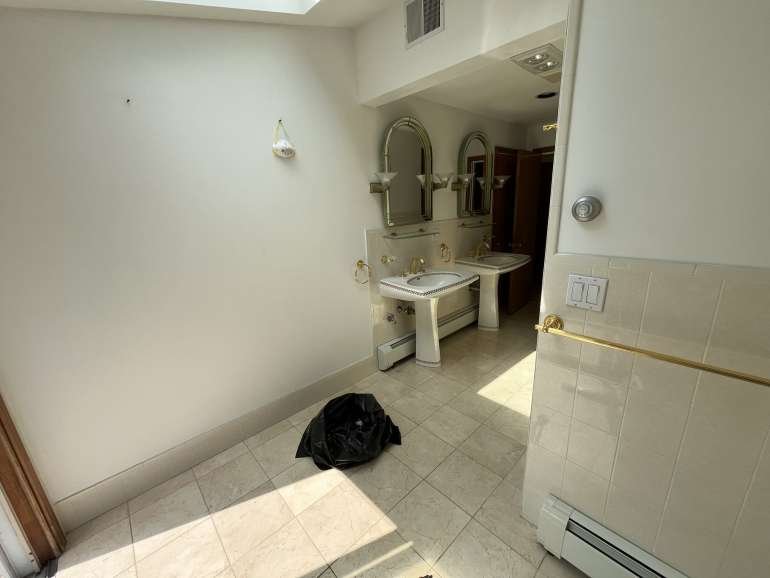 Outdated Newton MA bathroom with worn vanity, dated tile, and dim lighting before Sun Shore remodel