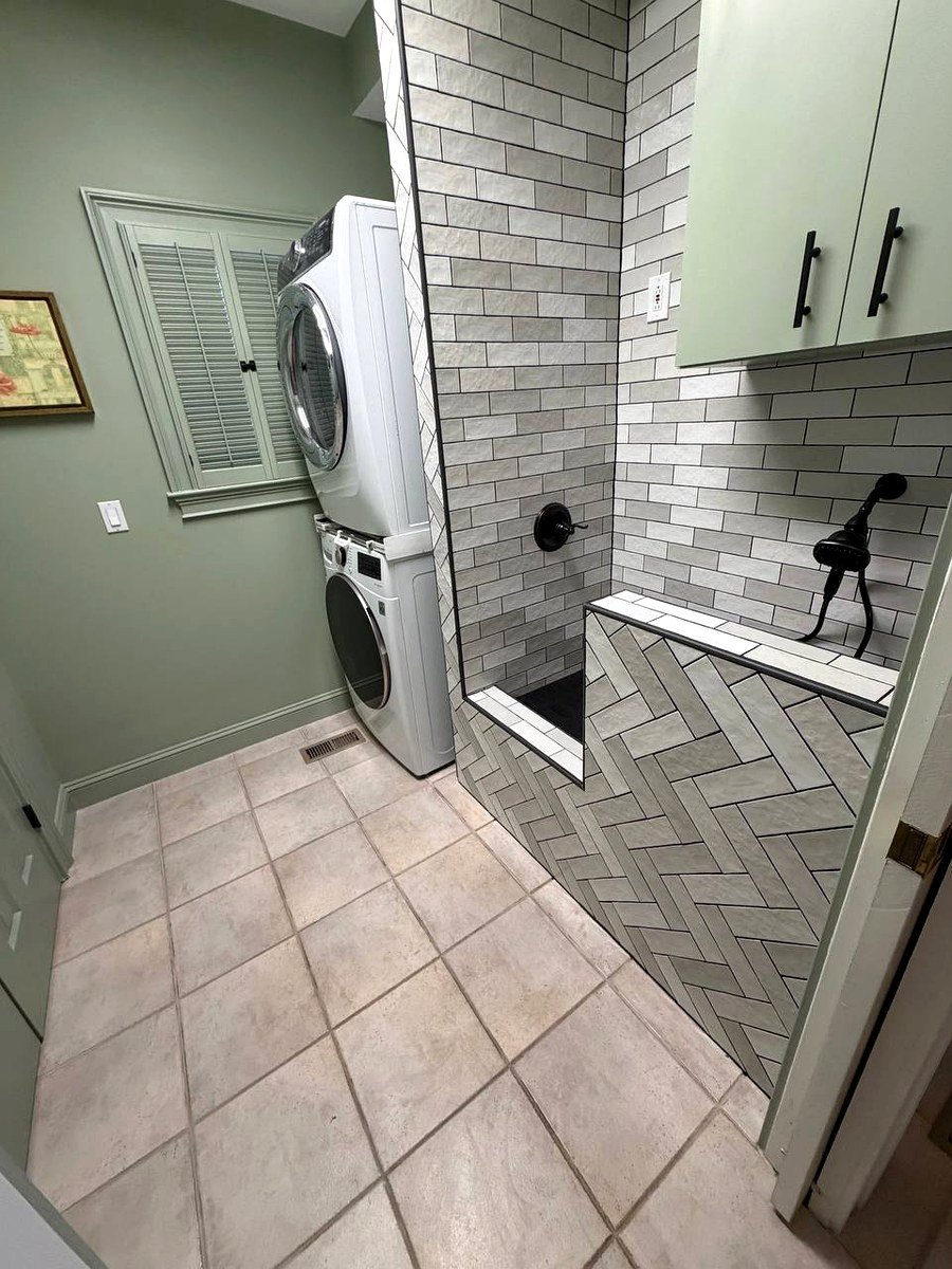 Laundry room renovation Weston MA - dog wash station with stacked washer, gray subway tile, and herringbone tile floor