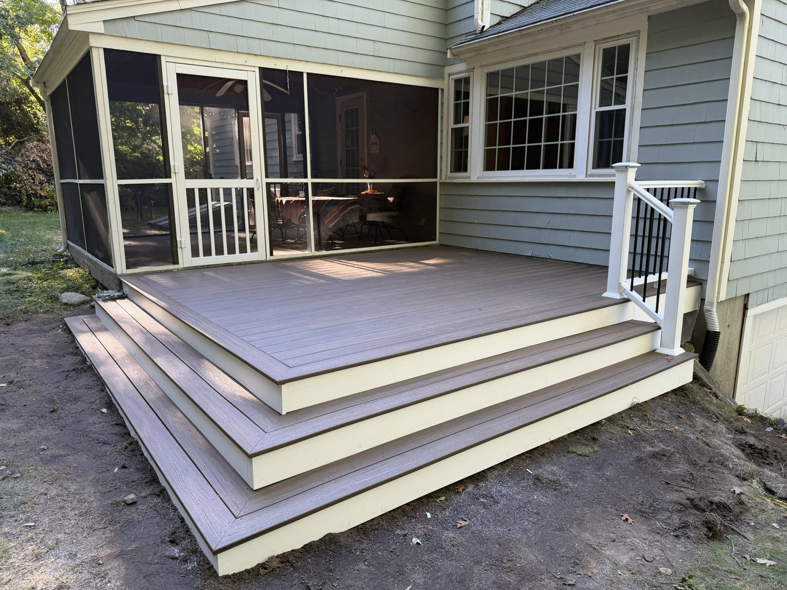 acton-ma-trex-composite-deck-wraparound-steps-screened-porch Trex composite deck with wraparound steps beside a screened porch in Acton, MA