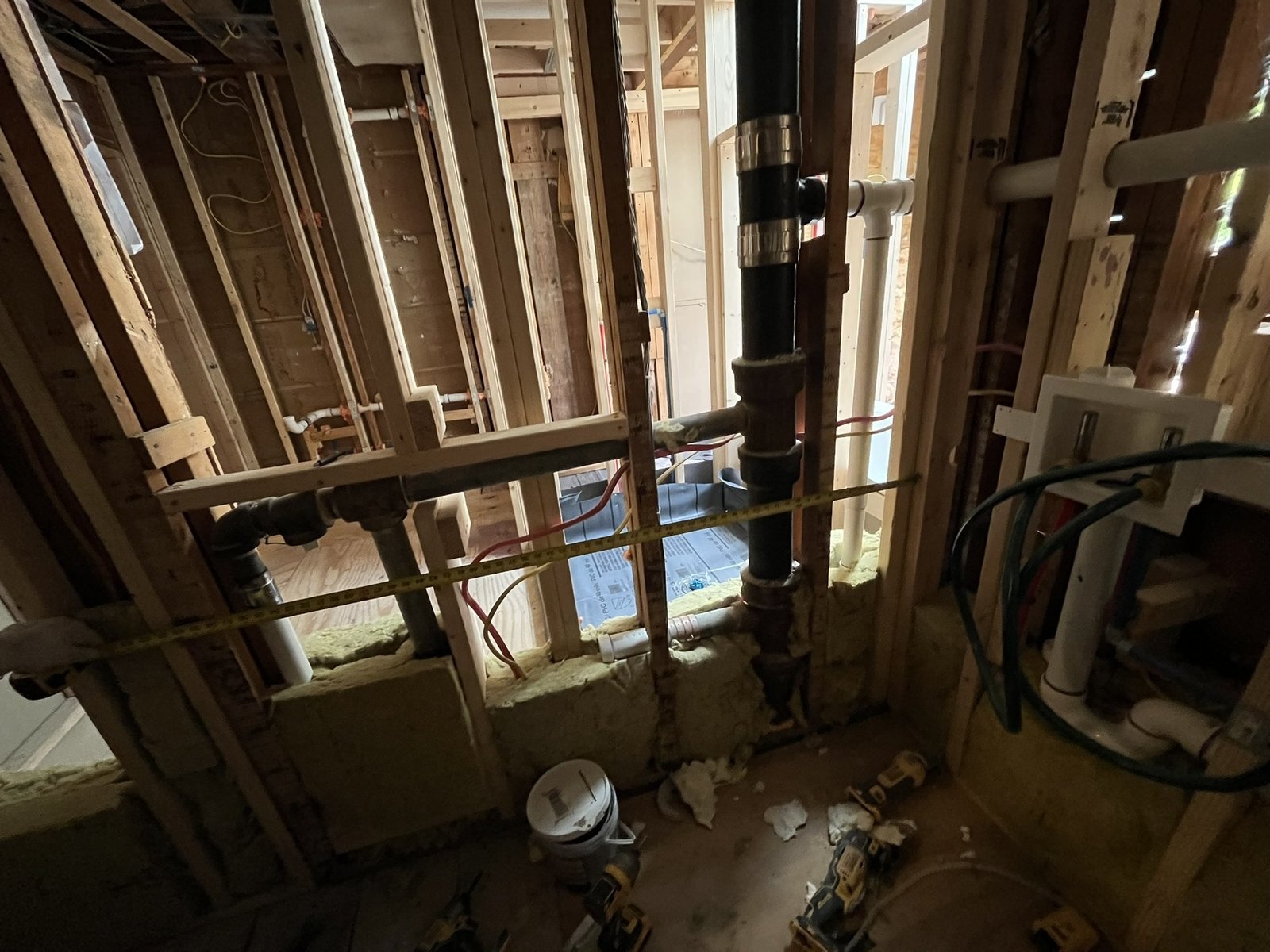 Gutted bathroom with new drain stack, supply lines and wall framing for a new floor plan